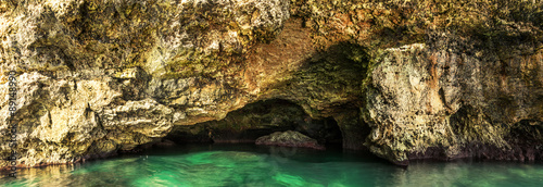 Beautiful sea cave and sun reflections on the rocks and in the water