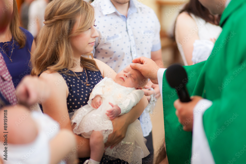 Mother hold baby on ceremony of child christening in church - obrazy, fototapety, plakaty 