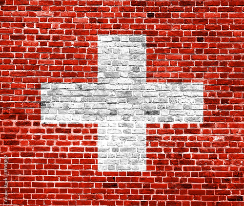 Flag of Switzerland painted on brick wall, background texture