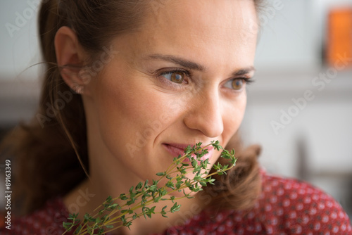 Closeup of woman smelling fresh thyme