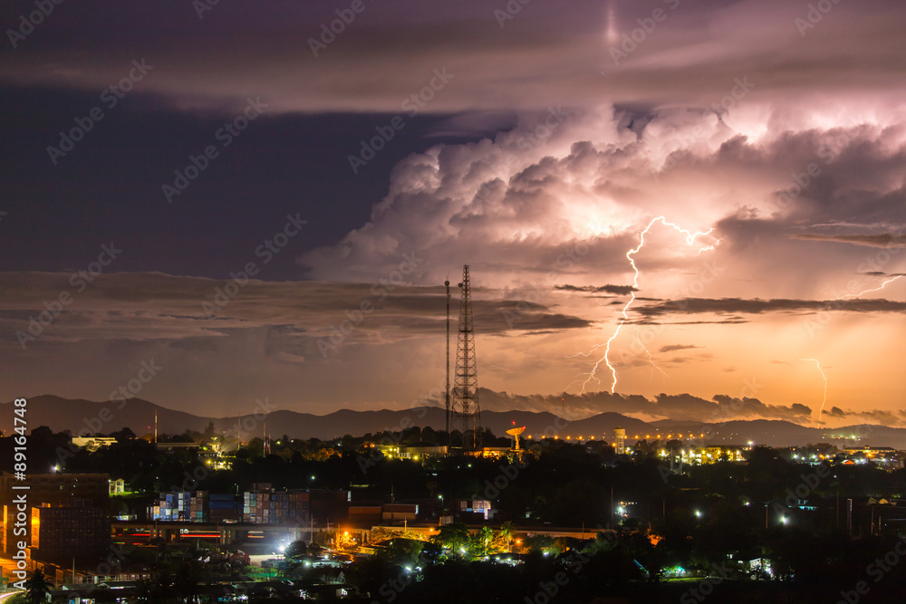 Naklejka premium Sky with lightning striking hills behind small town