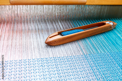 Obraz na płótnie Weaving shuttle on the color warp