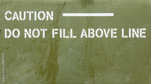 Green metal with caution sign painted on it