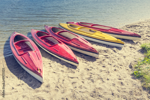 Fototapeta Naklejka Na Ścianę i Meble -  Colorful kayaks moored on lakeshore, Goldopiwo Lake, Mazury, Pol