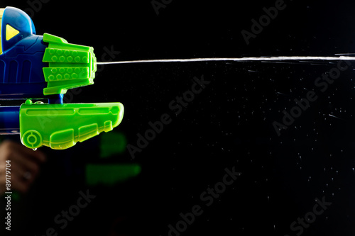 Foto water squirt pistol gun shootinh water on black