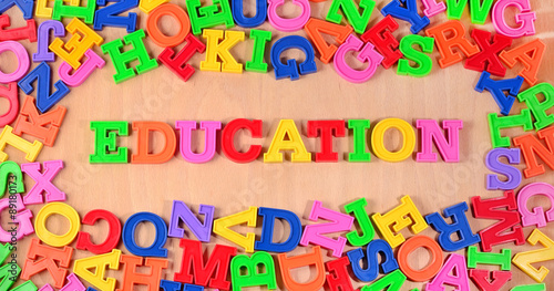 Education written by colorful letters on a wooden background
