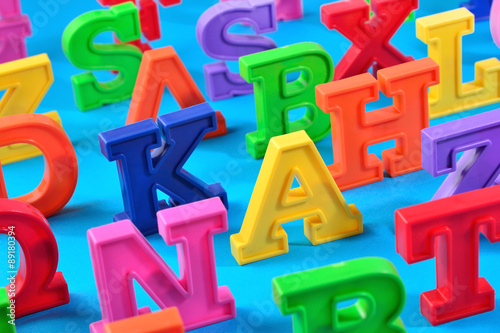 Plastic colorful alphabet letters close up on a blue