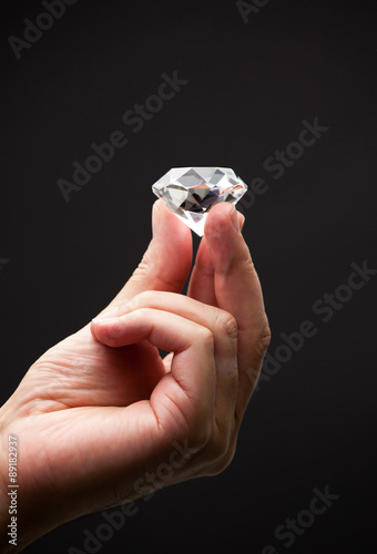 Close up of a hand holding a diamond