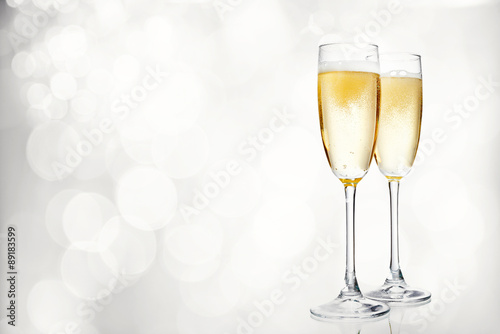 Glasses of champagne on bright background