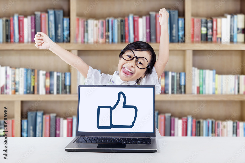 Successful kid raise hands in library Successful kid raise hands in library