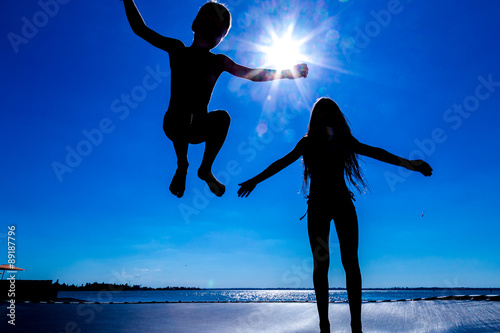 Two kids jumping on trampoline photo