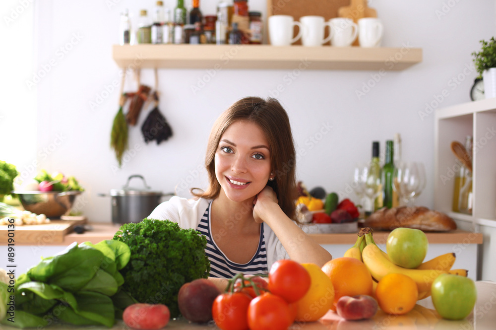 Young woman sitting near desk in the kitchen