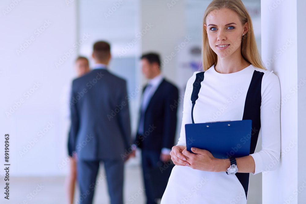 Portrait of young businesswoman in office with colleagues in the Portrait of young businesswoman in office with colleagues in the