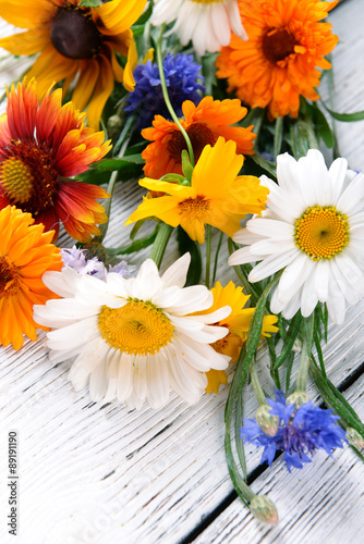 Bright wildflowers on wooden table, closeup