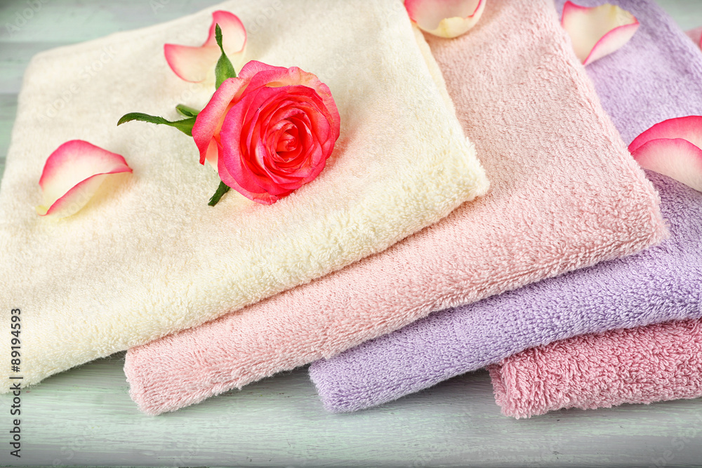 Stack of colorful towels on light wooden background Stack of colorful towels on light wooden background