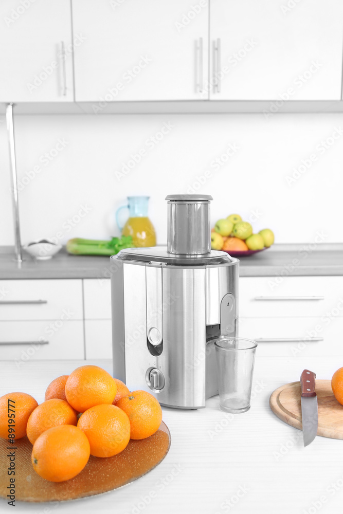 Juicer and fruits on table in kitchen, close up Juicer and fruits on table in kitchen, close up