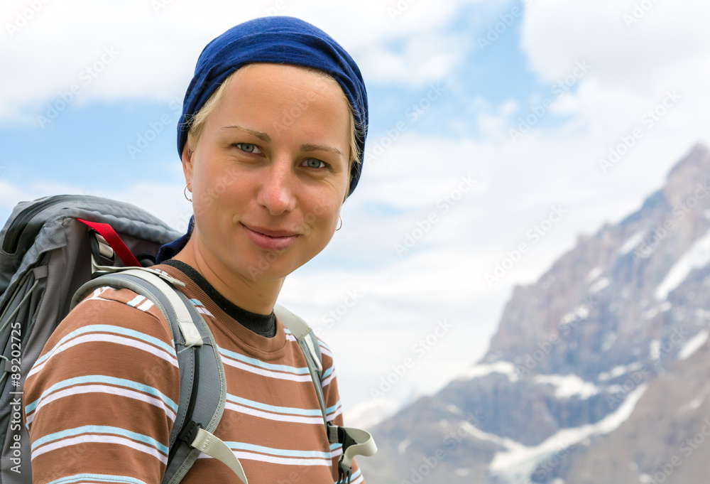 Optimistic and confident female hiker Portrait of optimistic European blond woman with backpack look in camera mountain landscape background Optimistic and confident female hiker Portrait of optimistic European blond woman with backpack look in camera mountain landscape background