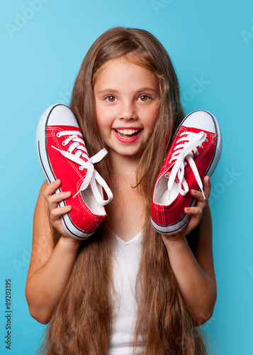 Young smiling girl with red gumshoes photo