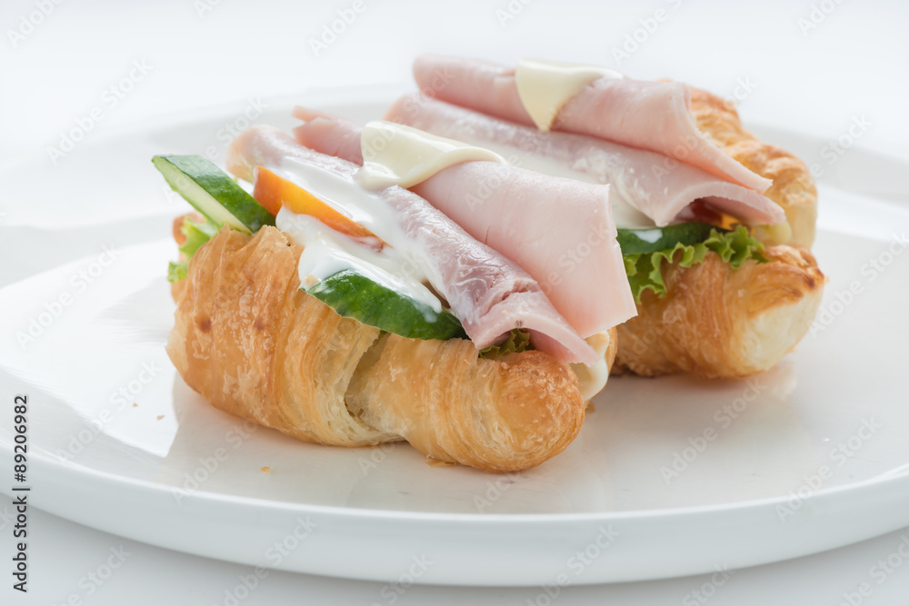 Croissant ham cheese sandwich on white plate Croissant ham cheese sandwich on white plate