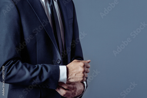 man in suit on a grey background, hands closeup