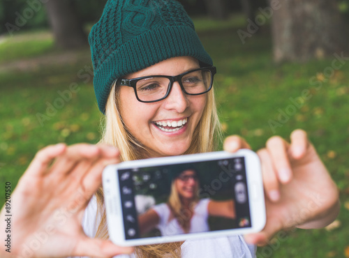 Blonde woman posing outdoor, taking self portrait photo