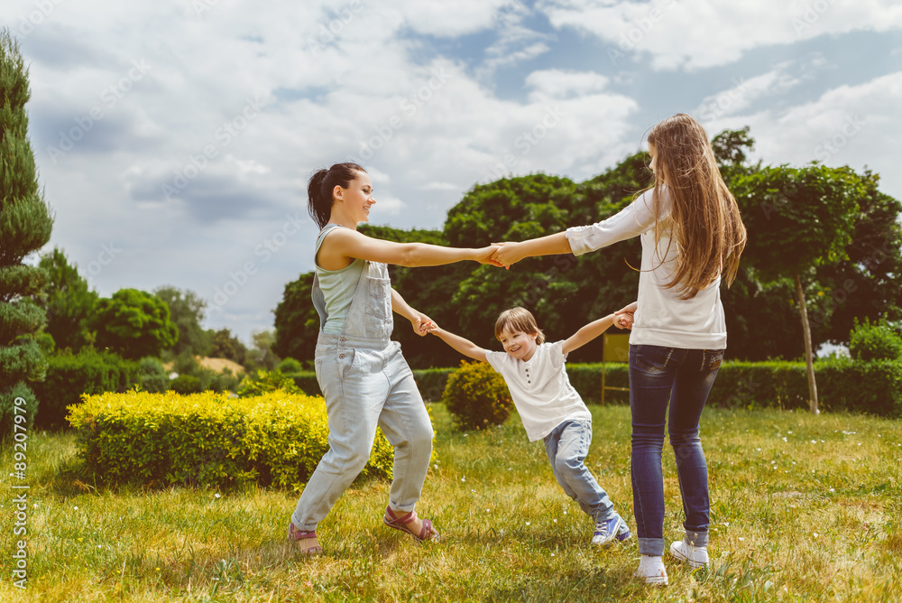 Happy Mother with daughter and son playing on grass smiling Happy Mother with daughter and son playing on grass smiling