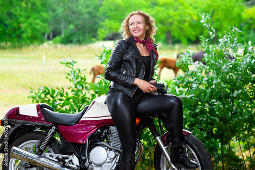 Biker girl in leather jacket on a motorcycle