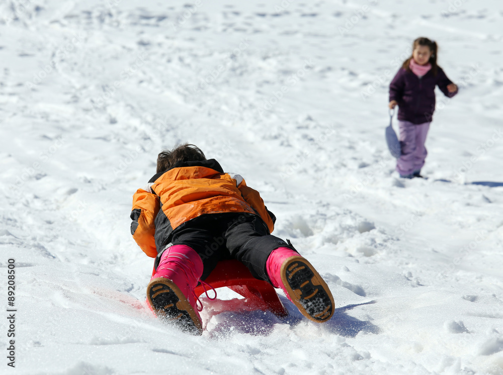 Children plays with sledging in winter on the snow Children plays with sledging in winter on the snow