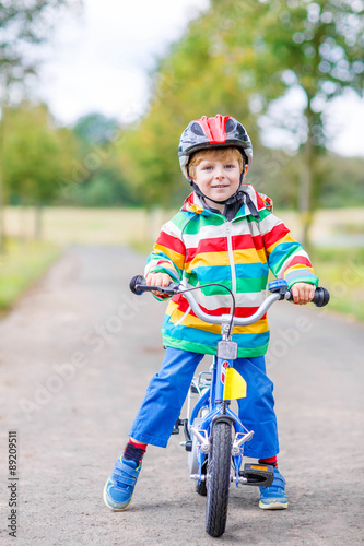 Cute active little boy riding on bike
