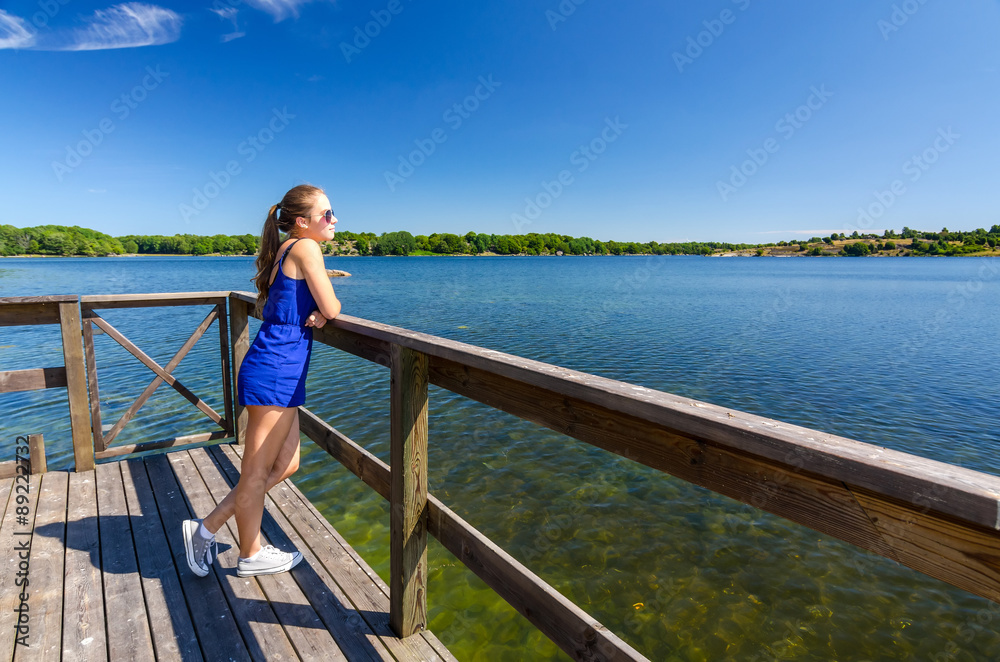 Girl enjoy summer landscape on sea bridge