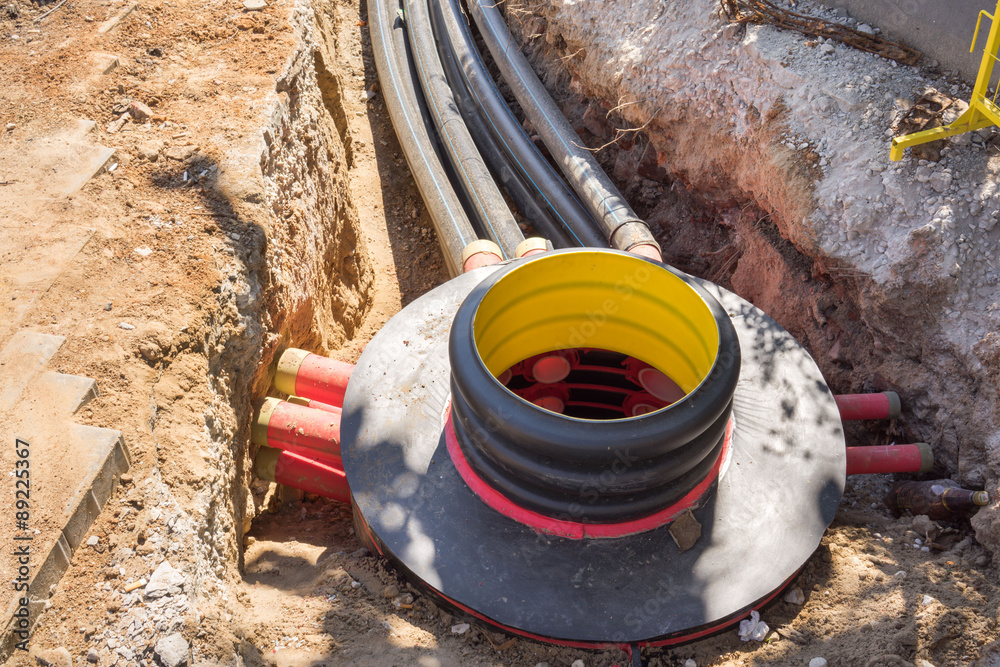 Excavation pit, electrical cables and optical fibres in the digging on