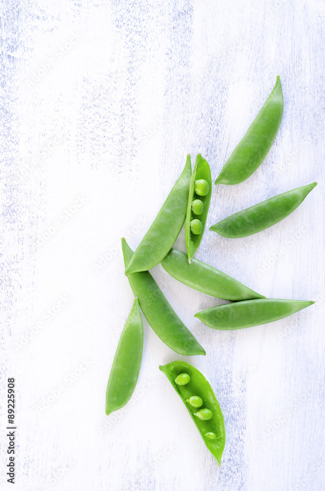 Naklejka Fresh green peas on rustic white background
