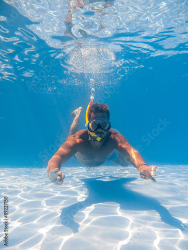 Full length of a young man wearing snorkel underwater