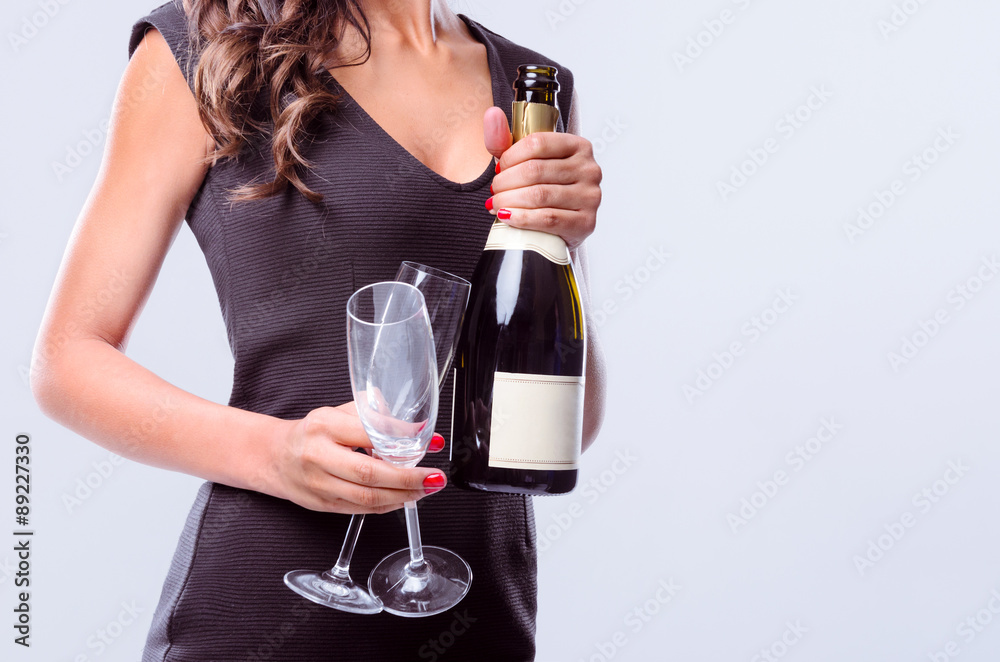 Hands holding bottle of sparkling wine and champagne flutes