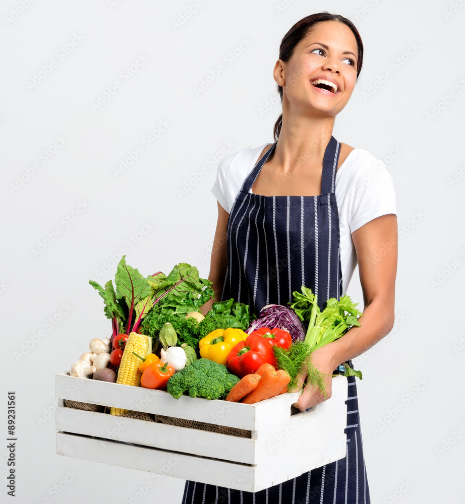 Smiling chef with apron holding fresh local organic produce Smiling chef with apron holding fresh local organic produce