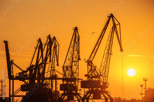  Silhouette of sea port cranes in the evening