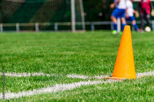 orange leitkegel auf dem rasenplatz beim fußball photo