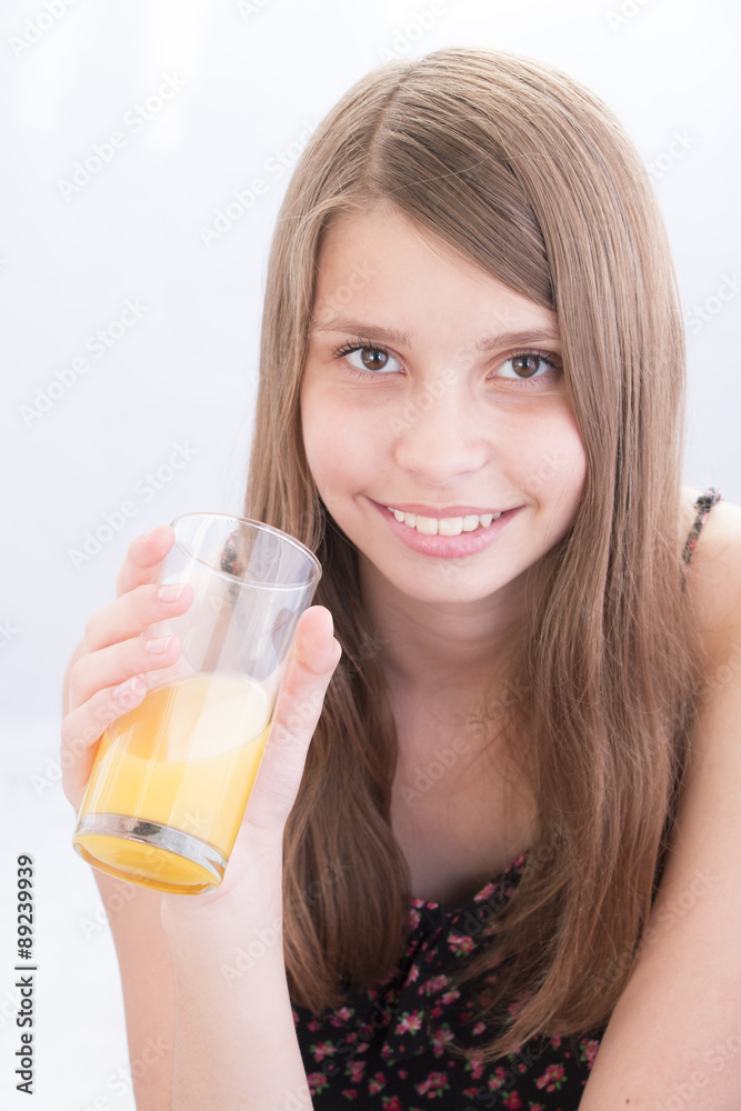 Smiling teenage girls drinking orange juice
