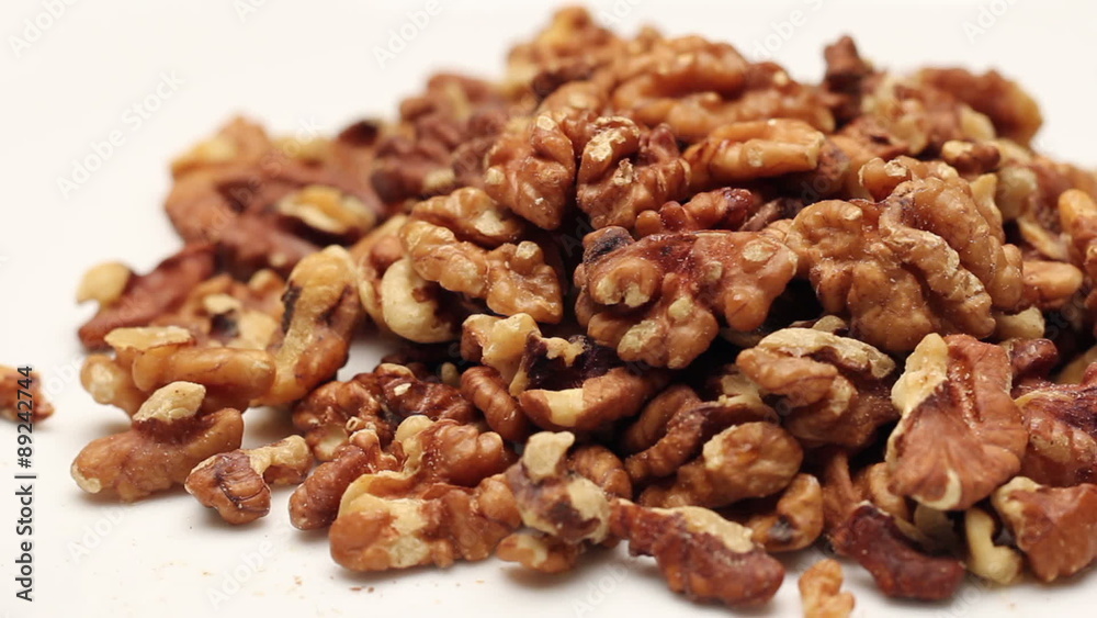 Heap of walnut kernels isolated on white, rotating 
