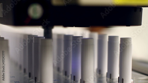 A wide angle and a close-up shot of an automated machine which uses cameras to perform product inspections at a microscopic level. 
