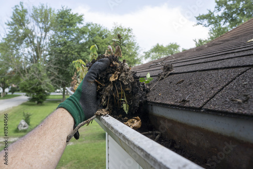 Cleaning Gutters Filled With Leaves & Sticks photo
