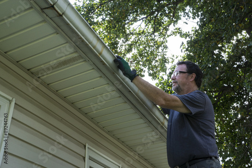 Cleaning Gutters Of Leaves And Sticks