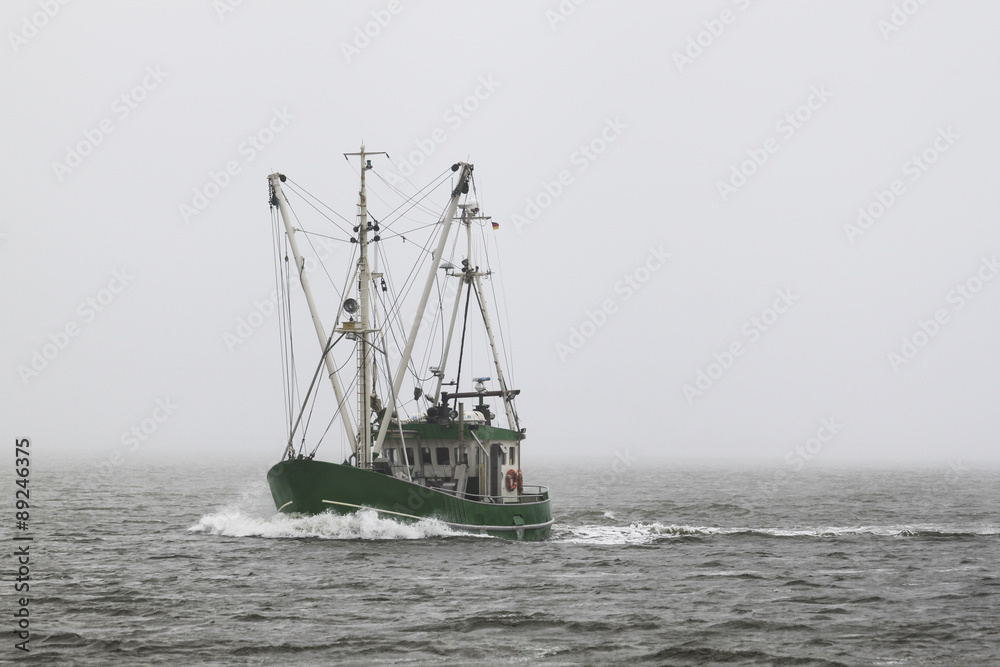 Grüner Fischkutter im Nebel