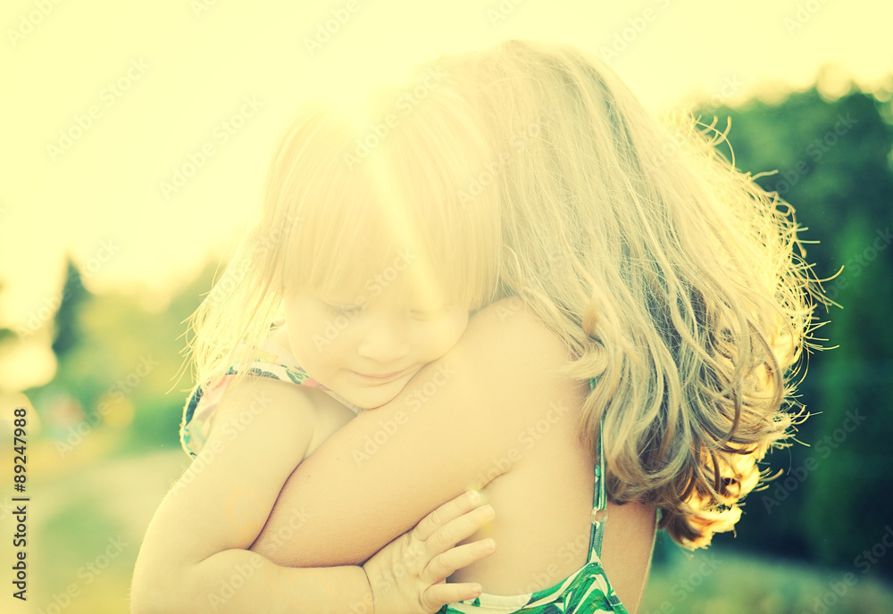 Two sisters Cuddled up together. Back lighting sunlight.