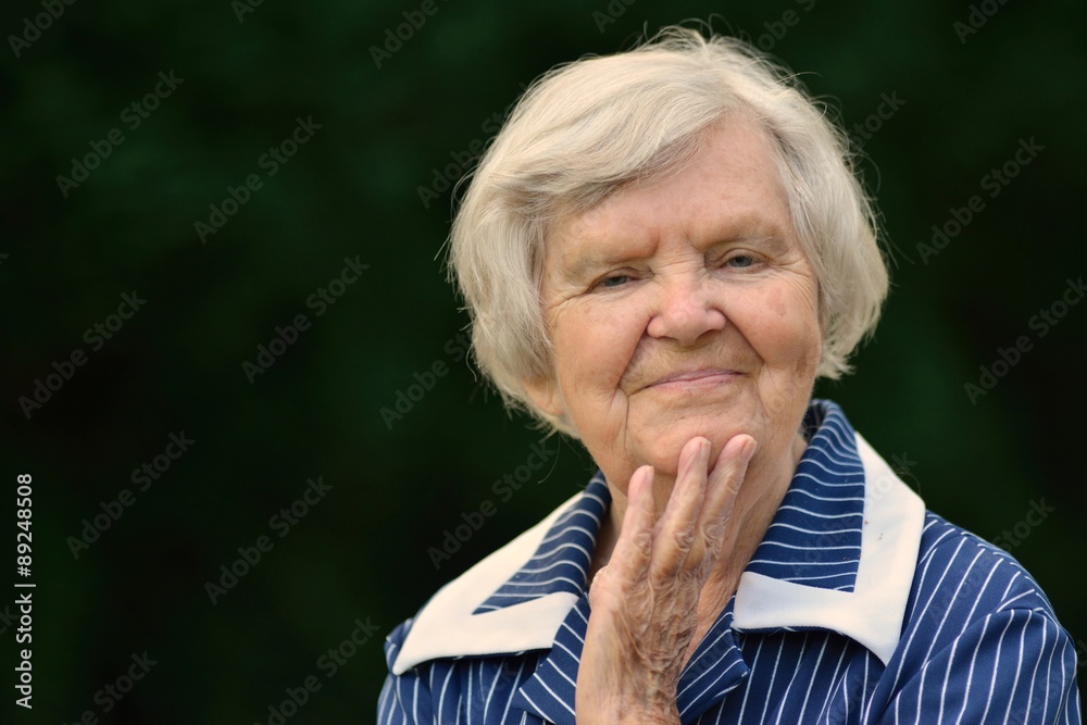 Senior woman smiling and dreaming in garden. Senior woman smiling and dreaming in garden.
