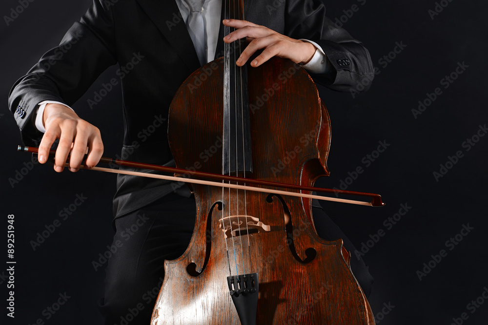 Man playing on cello on dark background Man playing on cello on dark background