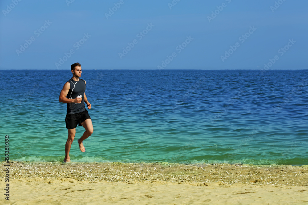 Young man jogging on beach