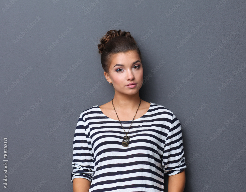 Young woman standing, isolated on gray background Young woman standing, isolated on gray background