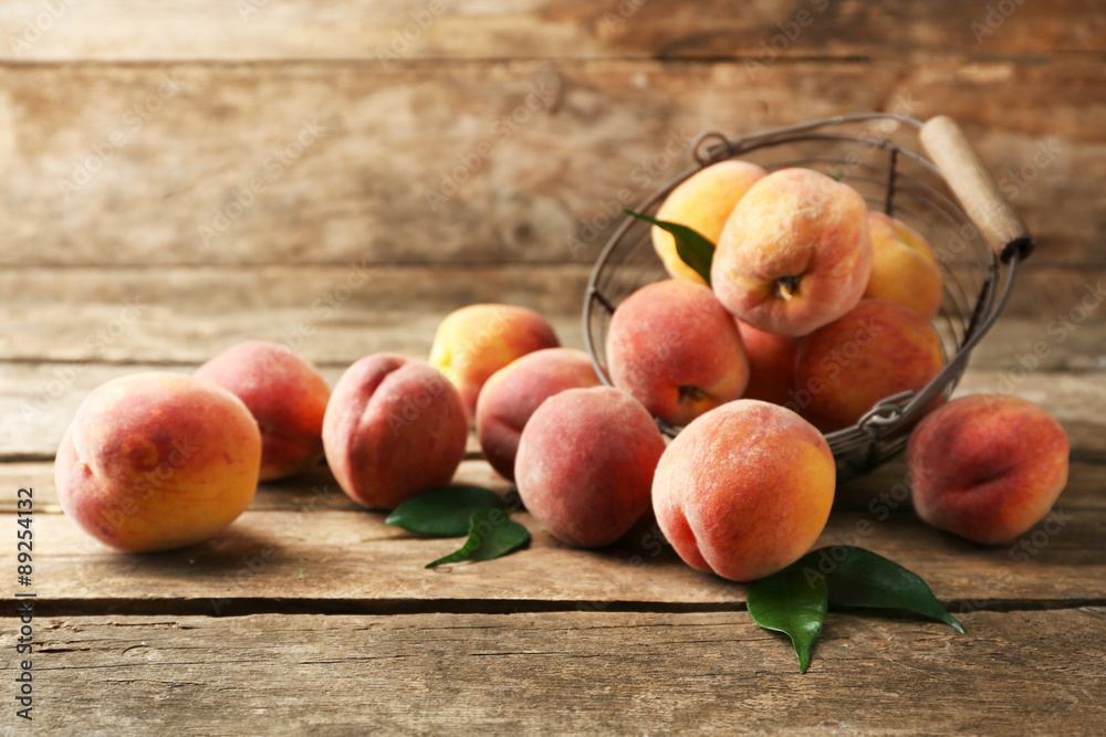 Ripe peaches in basket on wooden background Ripe peaches in basket on wooden background