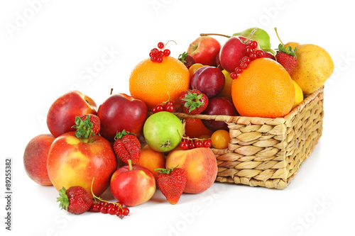 Heap of fresh fruits and berries in basket isolated on white